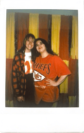 Two women wearing football jerseys smiling for a photo