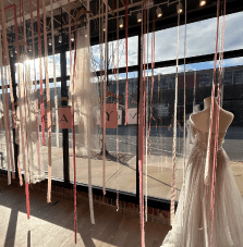 Wedding dress storefront design with draped ribbons, hangers and paper that say VOWREADY